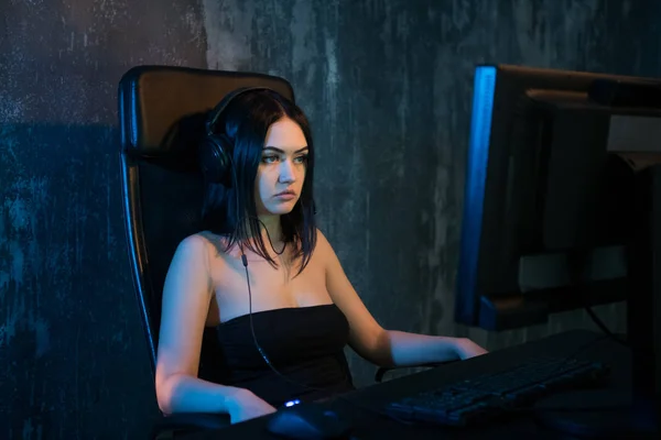 Gamer chica sentada en una silla cómoda en el ordenador y jugando a los videojuegos. La mujer joven descansando en casa en los juegos de ordenador . —  Fotos de Stock