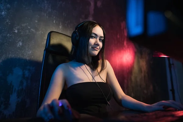 Chica gamer en los auriculares y con un ratón de la computadora en su mano streaming playthrough o video walkthrough . — Foto de Stock