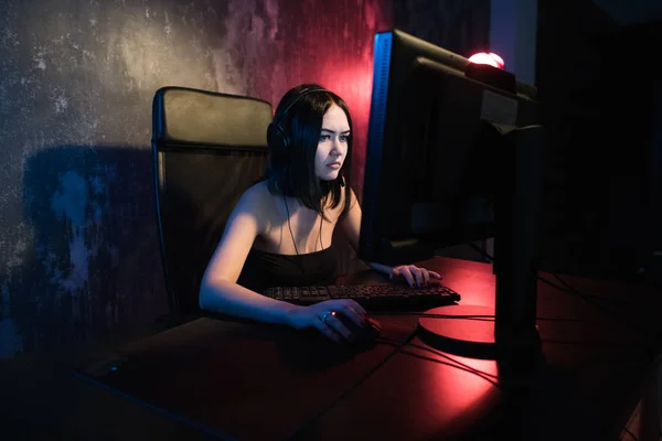 Gamer chica sentada en una silla cómoda en el ordenador y jugando a los videojuegos. La mujer joven descansando en casa en los juegos de ordenador . —  Fotos de Stock