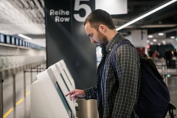 Ευτυχισμένος άνθρωπος χρησιμοποιώντας το μηχάνημα check in του αεροδρομίου να πάρει την κάρτα επιβίβασης — Φωτογραφία Αρχείου
