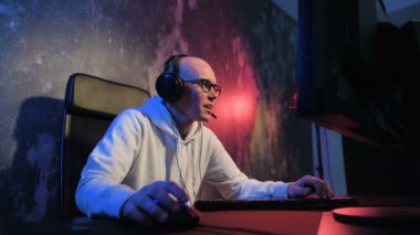 Çevrimiçi Video Oyunu 'nda oynayan Genç Profesyonel Oyuncu, Mikrofon aracılığıyla Takım Oyuncuları ile konuşuyor. Neon renkli oda. E-Spor Sanal Oyunları İnternet Şampiyonası