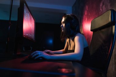 kız oyun kulaklık ve bir klavye ve fare e-spor uluslararası yarışmalara katılmaya hazırlanıyor ağ oyun oynarken onun elinde