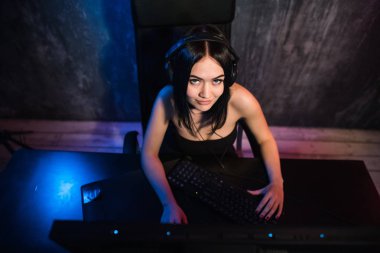 Kız oyun kulaklık ve playthrough veya anlatım video akarsu onun elinde bir bilgisayar fare ile.