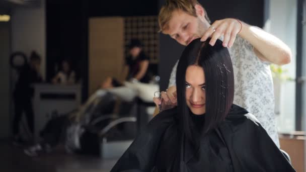 Usmívající se vlasy kadeřnice kadeřnictví a klient zároveň nový účes na krásná brunetka žena v salonu — Stock video