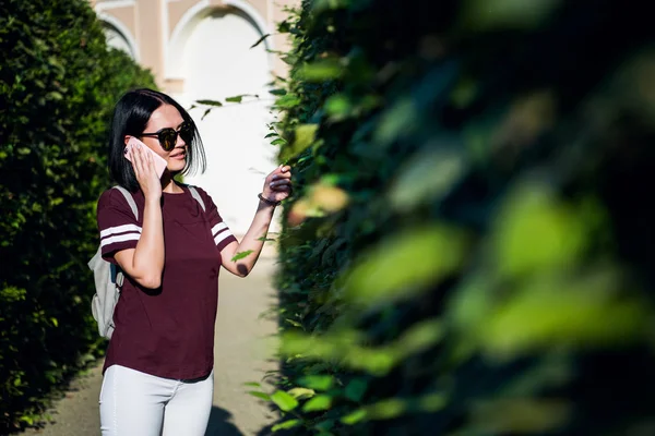 Hermosa joven hablando por teléfono en el parque de la ciudad . — Foto de Stock