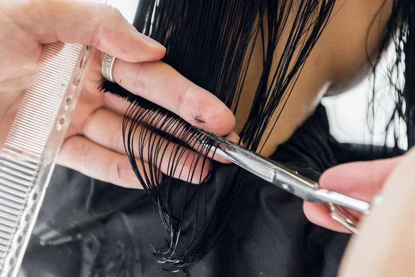 Hairdresser cutting clients hair in salon with scissors closeup. Using a comb — Stock Photo, Image