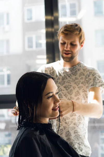 Щаслива молода жінка отримує нову зачіску від перукаря в салоні — стокове фото