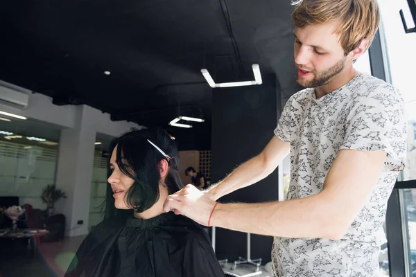 Cabeleireiro com pente e tesoura corte de cabelo de cliente feminino. Mulher no salão de beleza de cabeleireiro . — Fotografia de Stock