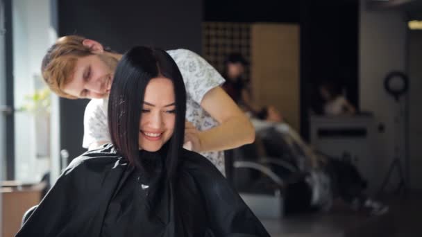 Mujer atractiva sonriendo mientras tiene una consulta con su estilista . — Vídeos de Stock