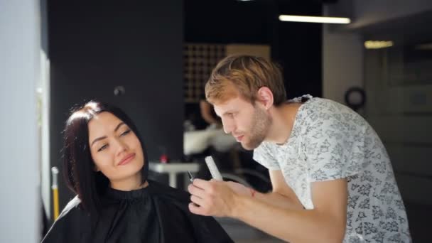 Szczęśliwa młoda kobieta zaczyna nową fryzurę przez fryzjera w salonie — Wideo stockowe