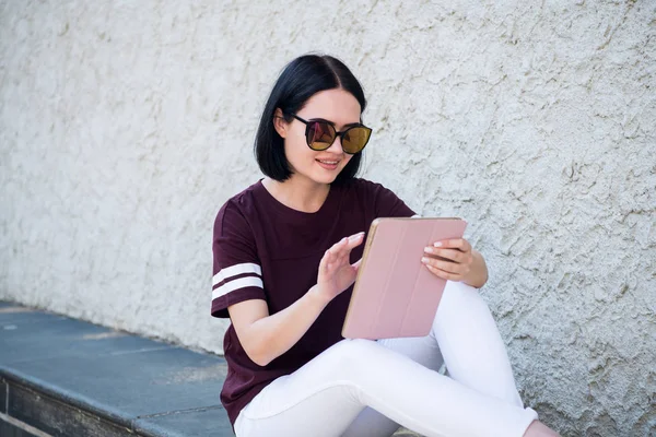 Primer plano de la mujer feliz en gafas usando tableta PC en la calle — Foto de Stock