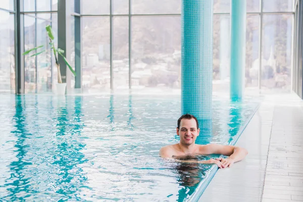 Tiro de un joven guapo feliz hombre en la piscina cubierta — Foto de Stock