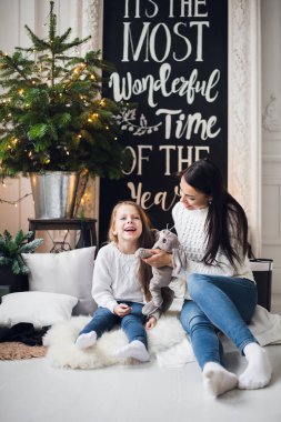 Şirin kızlar kız hediye kutuları ile Noel ağacı yanında oturan.