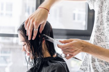 Genç güzel kadın saçlarını Kuaför kesilmiş olması. Gülümseyen ve saç modeli için müşteri yapma genç erkek kuaför.