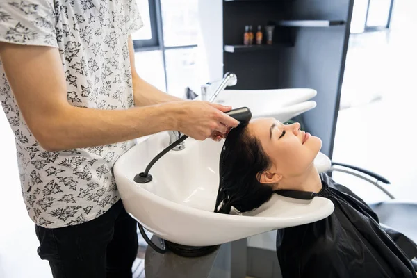 Krásná brunetka myje vlasy v salonu krásy — Stock fotografie