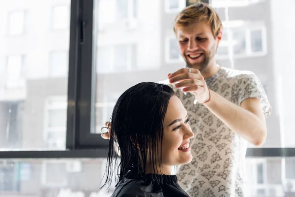 Rindo menina e cabeleireiro falando e sorrindo ao fazer um novo corte de cabelo ou penteado — Fotografia de Stock