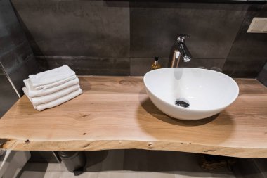 Banyo modern iç. Lavabo beyaz büyük kabuk ahşap masanın üzerinde yapılır. Minimalizm ve sadelik bir parlak gri fonksiyonel iç. Üstten görünüm