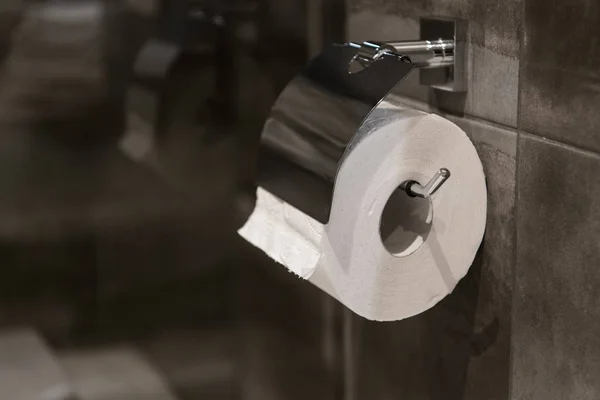 Toilettenpapierrolle im Bad gegen graue Wandfliesen — Stockfoto