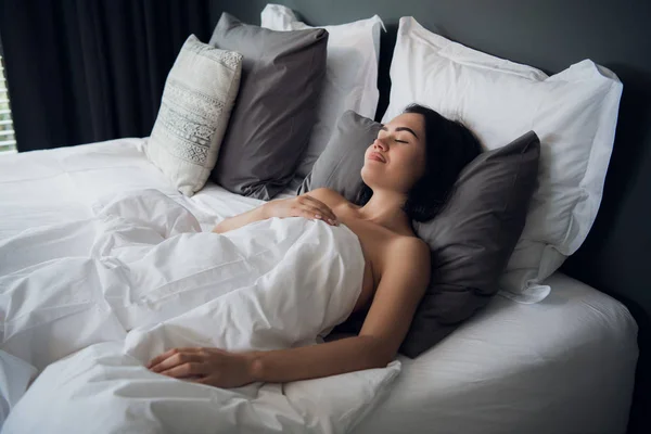 Hotel, viaje y concepto de felicidad - hermosa mujer durmiendo en la cama — Foto de Stock