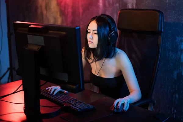 Όμορφη Επαγγελματική Gamer Girl Παίζοντας στο Shooter πρώτου προσώπου Online Video Game στον προσωπικό υπολογιστή της. Χαριτωμένο σπασικλάκι που φοράει γυαλιά και χαμογελάει. Cyber e-Sport Πρωτάθλημα Διαδικτύου. — Φωτογραφία Αρχείου