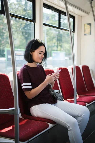 Νέα κοπέλα έφηβων χρησιμοποιώντας το κινητό της στα μέσα μαζικής μεταφοράς. — Φωτογραφία Αρχείου