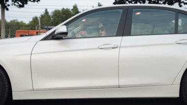 Otoriter bir kadın. Kendine güvenen genç işkadını park park yeri ve onu arabadan çıkan otomobili