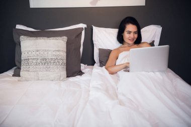 Evde yatakta otururken, Genç kadın laptop tarama uyandım