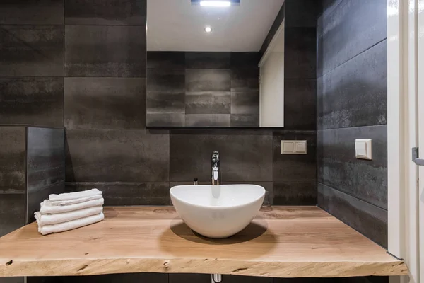 Modern interior of the bathroom. The washbasin is made of white massive shell on the table of wood. Minimalism and simplicity in a bright grey functional interior. Top view — Stock Photo, Image