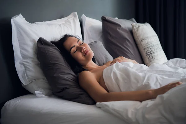 Szállás, utazás és a boldogság fogalmát - gyönyörű nő az ágyban alszik — Stock Fotó