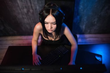 Güzel dost Pro Gamer kız yapar Video oyunu oyun akışı, giyen kulaklık görüşmeler ve kulaklık mikrofon içine onun hayranları ve takım ile sohbetler. Gençler eğleniyor. Arka plan Neon Retro renkleri