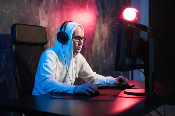 Macho con capucha gamer jugando juego en línea en el ordenador PC —  Fotos de Stock