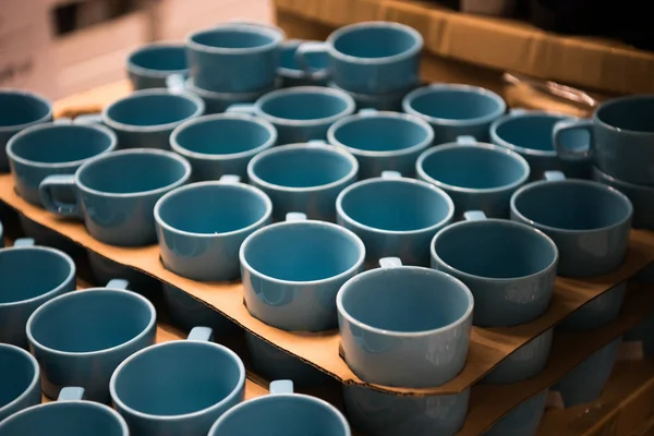 Tienda de copas de colores. Tazas de color azul aguamarina de pie En la tienda . — Foto de Stock