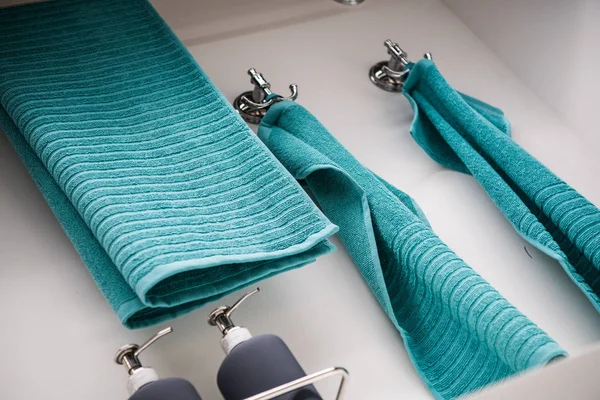 Um seco turquesa aqua azul toalhas penduradas em um cabides de prata no banheiro — Fotografia de Stock