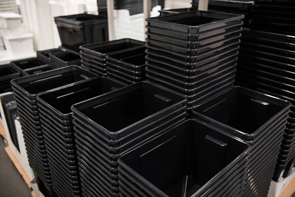 Boîtes en plastique noir en rangée en magasin — Photo