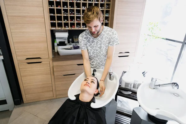 Menina bonita desfrutando de lavagem de cabelo no salão de cabeleireiro . — Fotografia de Stock