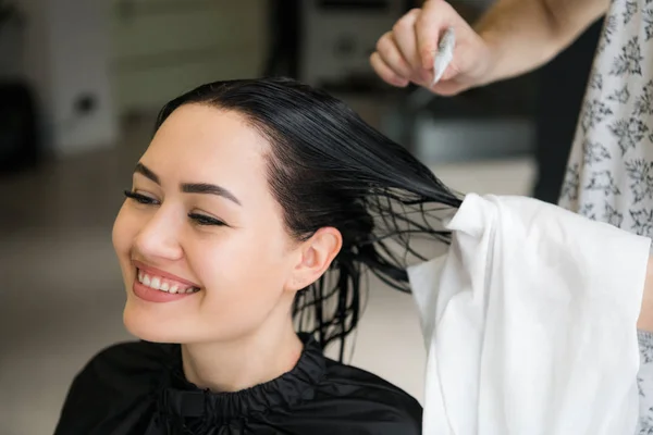 Coiffeur coupe les cheveux des femmes dans le salon, souriant, vue de face, gros plan, portrait — Photo