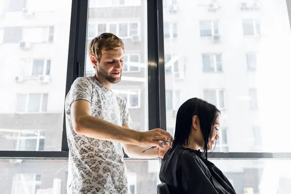 Cabeleireiro com pente e tesoura corte de cabelo de cliente feminino. Mulher no salão de beleza de cabeleireiro . — Fotografia de Stock