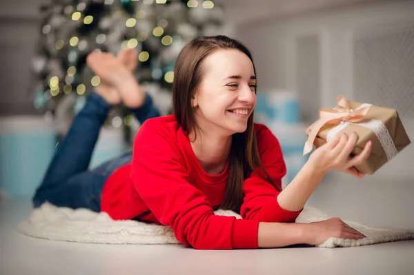 Portré gyönyörű nő ajándékkal ül a karácsonyfa otthon — Stock Fotó