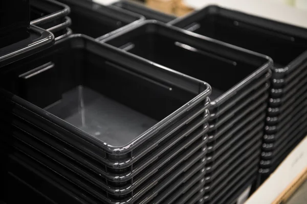 Schwarze Plastikboxen in Reihe im Geschäft — Stockfoto