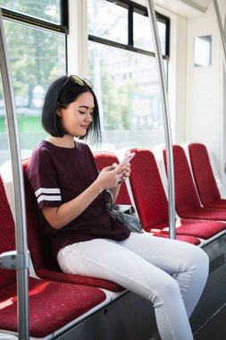 Kız otobüste seyahat ederken telefonunda.