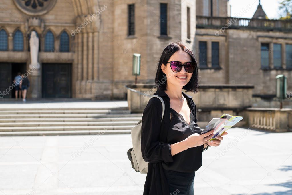 Travel guide, tourism in Europe, woman tourist with map on the street.