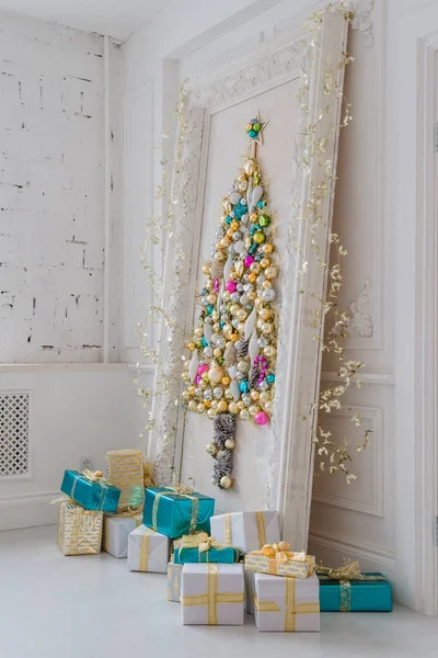 Hermoso salón interior decorado para Navidad. Gran marco de espejo con un árbol hecho de pelotas y juguetes —  Fotos de Stock