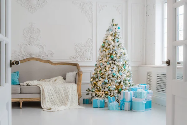 Snygg julinredning med en elegant soffa. Trösta dig hem. Presenterar gåvor under trädet i vardagsrummet — Stockfoto