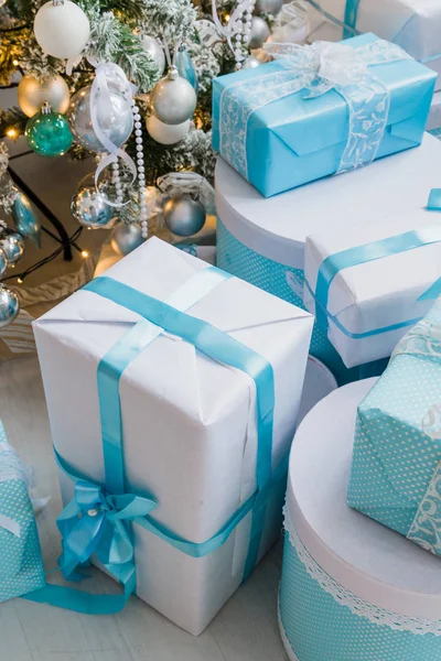 木製の表面に青い弓とボケライト付きのクリスマスギフトボックス — ストック写真