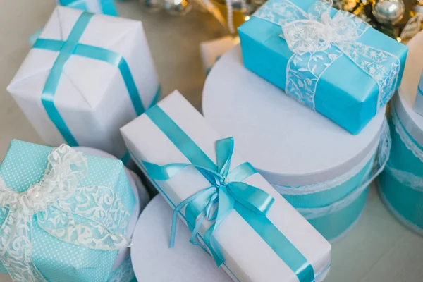 Karácsonyi ajándékok a díszített fa alatt kék ruhában — Stock Fotó