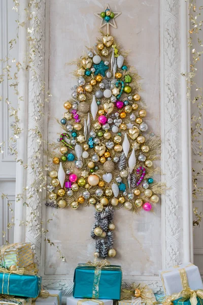 Hermoso salón interior decorado para Navidad. Gran marco de espejo con un árbol hecho de pelotas y juguetes —  Fotos de Stock