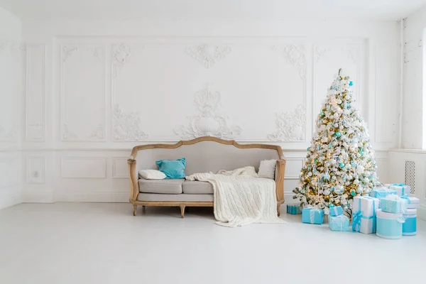 Stylový vánoční interiér s elegantní pohovkou. Pohodlí doma. Prezentuje dárky pod stromem v obývacím pokoji — Stock fotografie