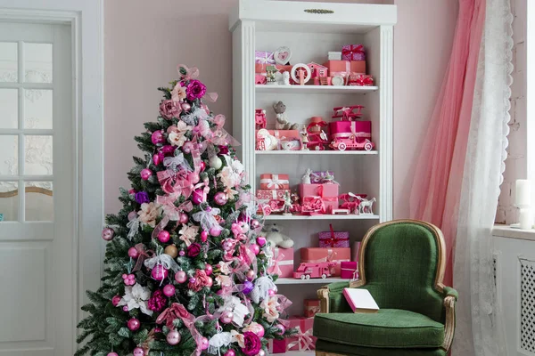 Krásné holdiay zdobené pokoje s vánočními stromky, police a růžové modré dárky na to, zelené křeslo domácí interiér — Stock fotografie