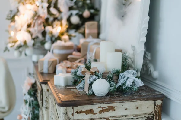 Decoración de Navidad en la antigua cómoda antigua vintage de cajones. Regalos artesanales hechos a mano, candeles y un árbol al fondo. Enfoque selectivo — Foto de Stock
