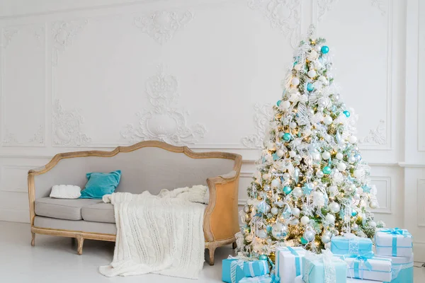 Elegante interior de Navidad con un elegante sofá. Hogar confortable. Regalos debajo del árbol en la sala de estar —  Fotos de Stock